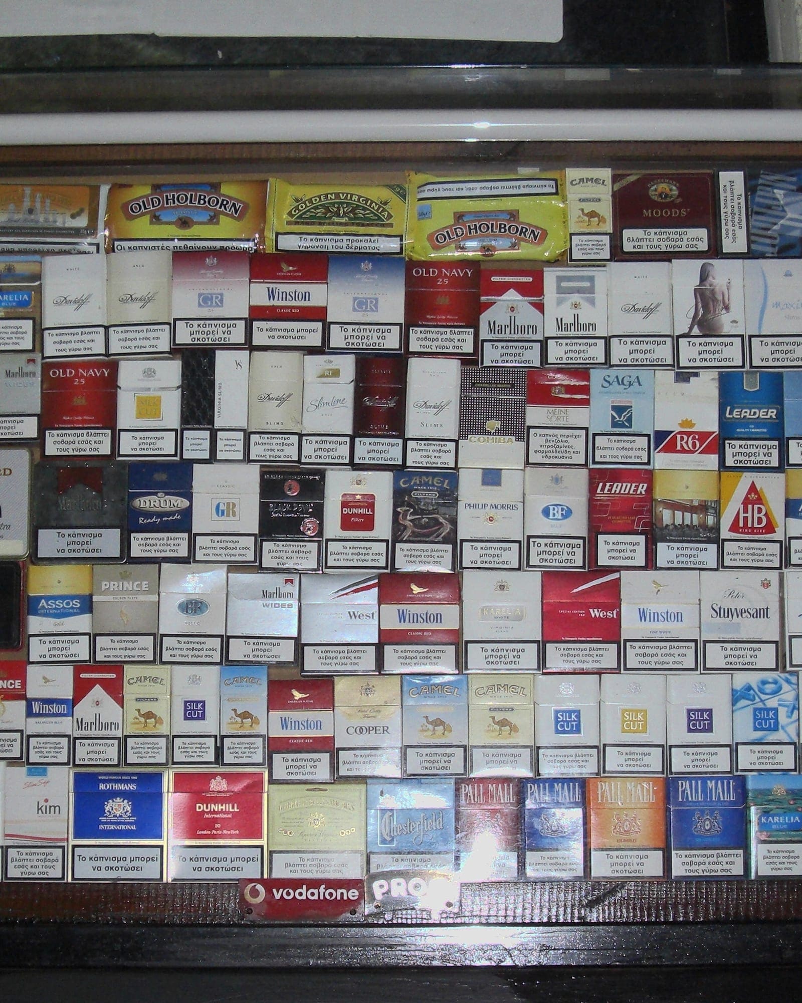 Cigarette packets displayed behind a shop counter.